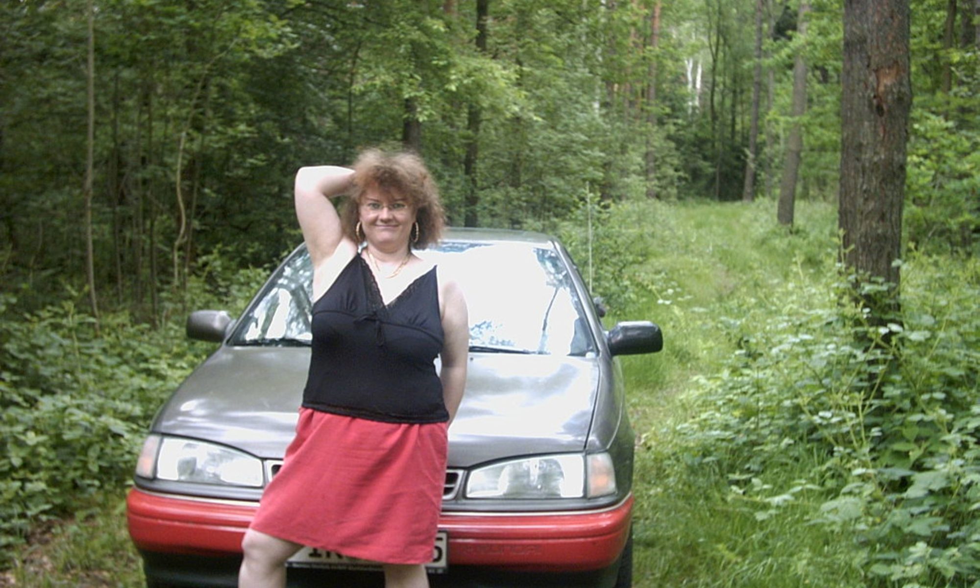Dicke Frau posiert auf dem Auto